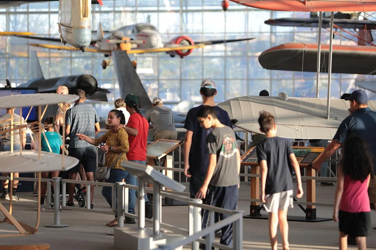 Families trying the hands-on flight-model benches in the Museum of Flight's education gallery