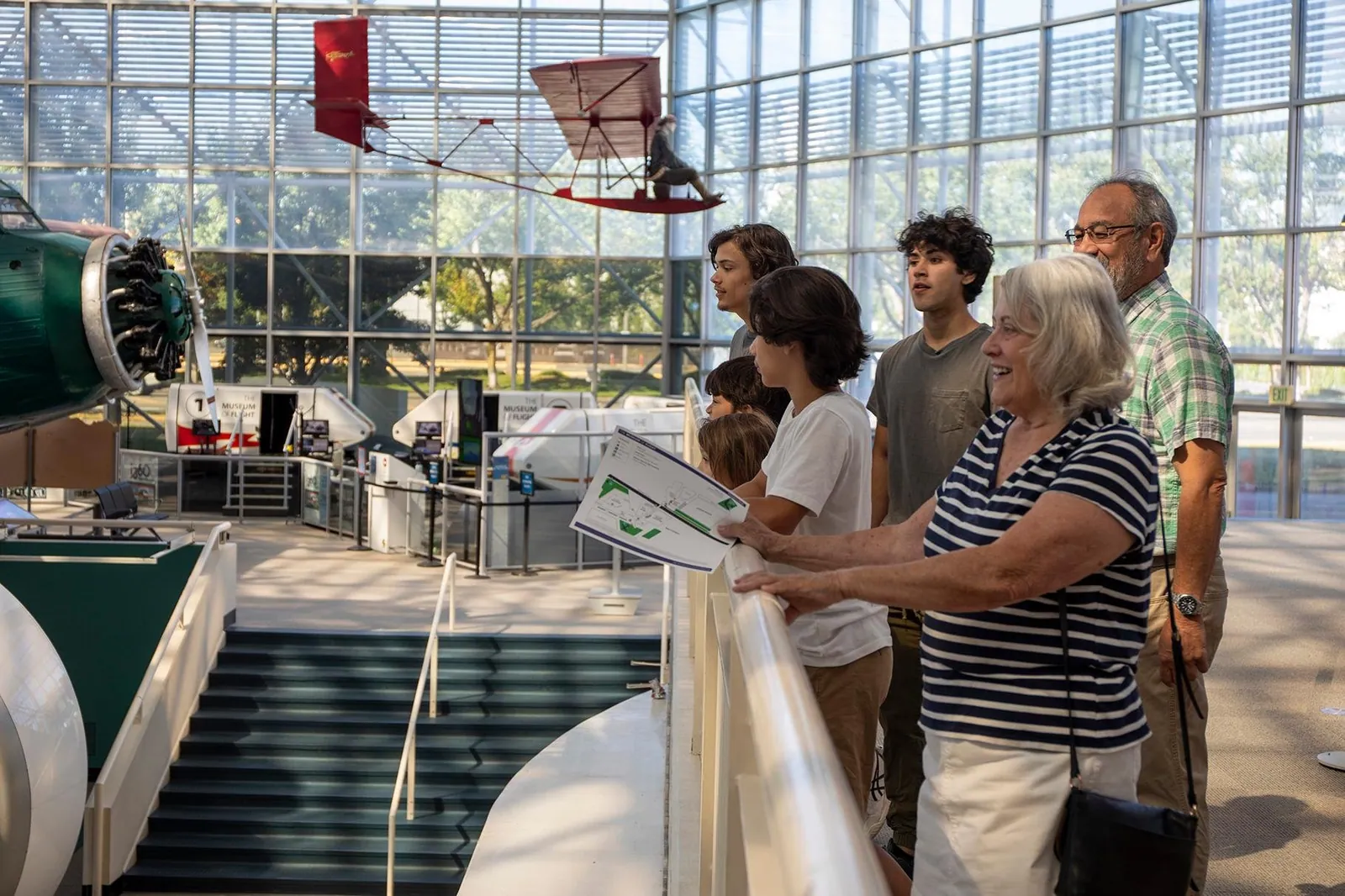 Visitors at a railing in the Museum of Flight's Great Gallery, with flight simulators on the floor below