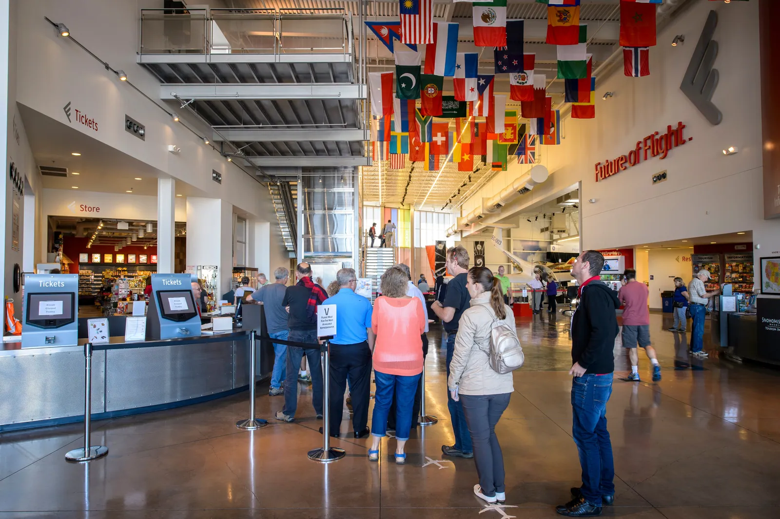 Visitors check in at the Future of Flight ticket desk beneath the flags of countries that fly Boeing aircraft