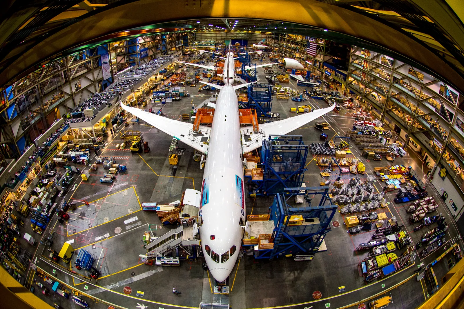 Overhead view of a widebody jet ringed by assembly tooling inside the Boeing Everett factory
