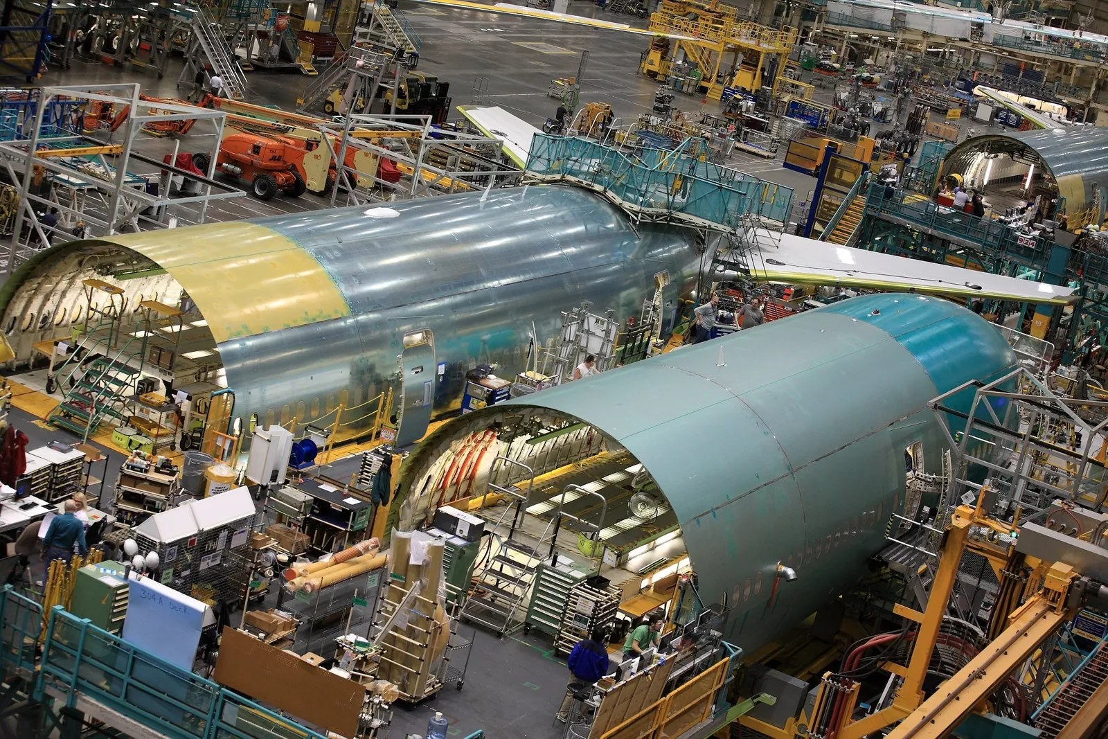Bare fuselage barrel sections in green primer waiting to be joined inside the Everett factory